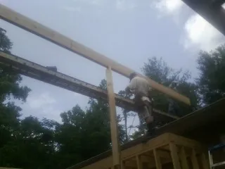 Carpenter setting a ridge beam over a new addition frame — Ice Dam Removal by Roofing Brothers in Boscobel