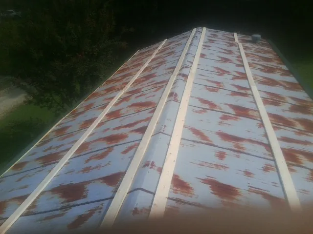 Rusted metal roof panels with new wood purlins before replacement — Storm Damage Roof Repair in Boscobel by Roofing Brothers