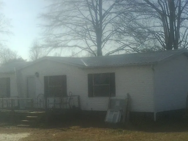 New metal roof on a white painted brick home on a foggy morning in Boscobel
