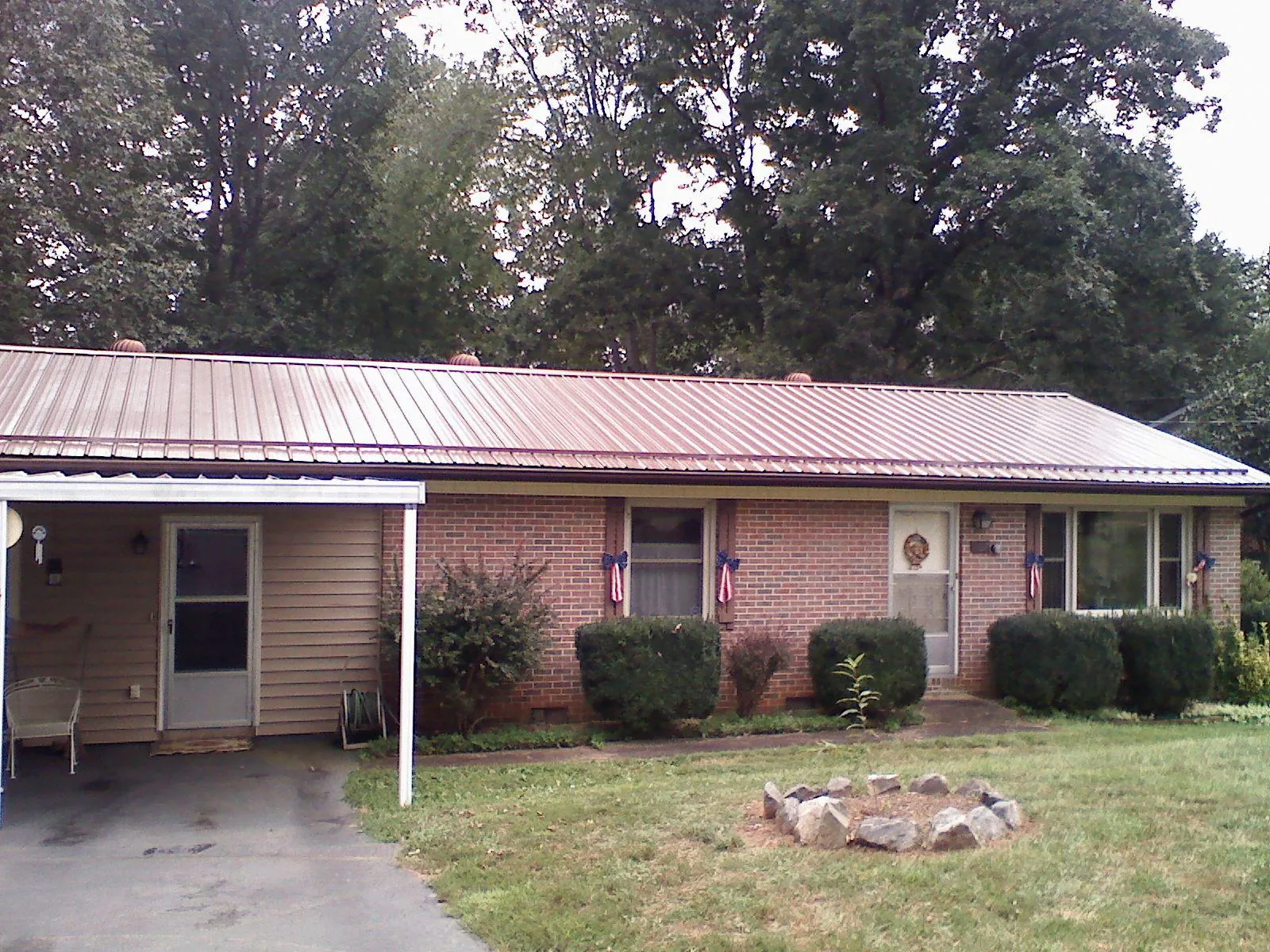 Bronze metal roof and carport on a brick ranch home — Roof Repair work by our crew in Boscobel